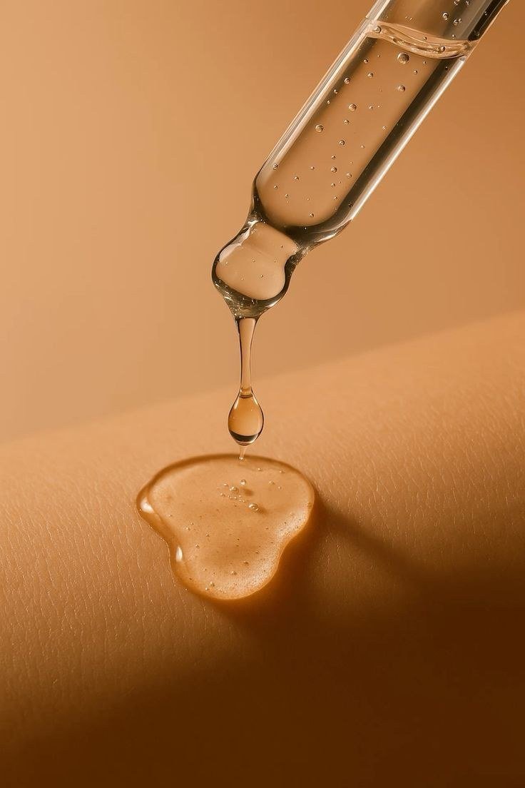 Gota de aceite cayendo de un gotero sobre la piel del brazo